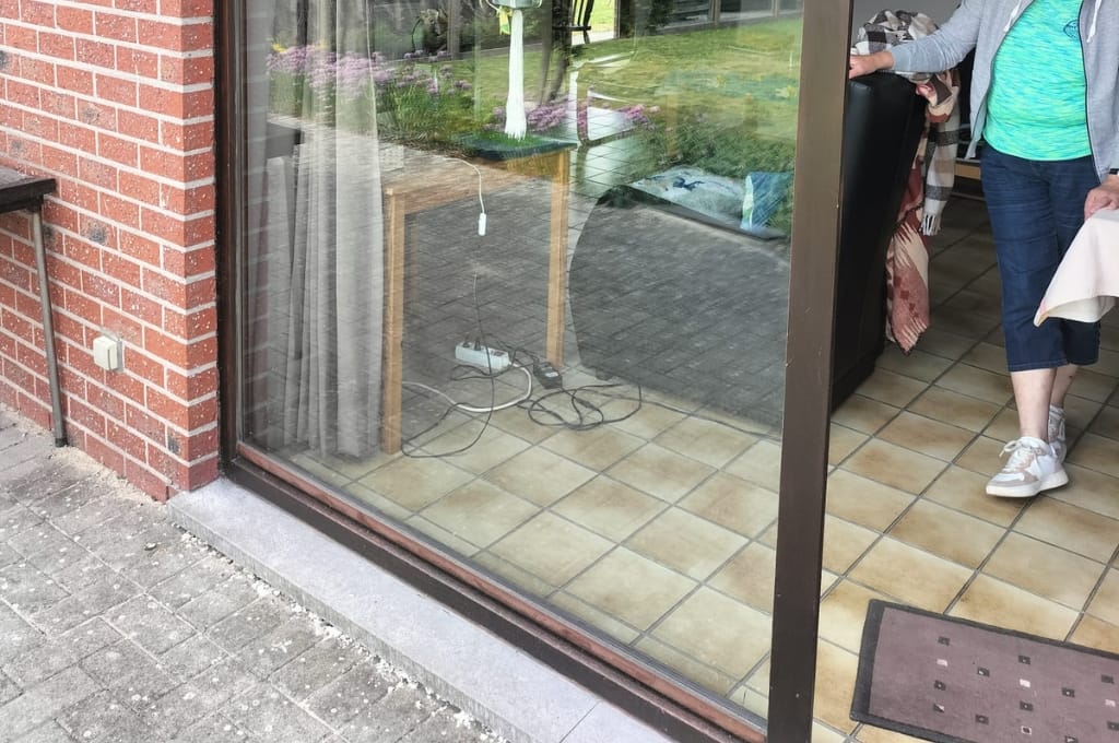 Homeowner cleaning the bottom track of a sliding glass door Austin using tools from a maintenance bundle in a Austin home.