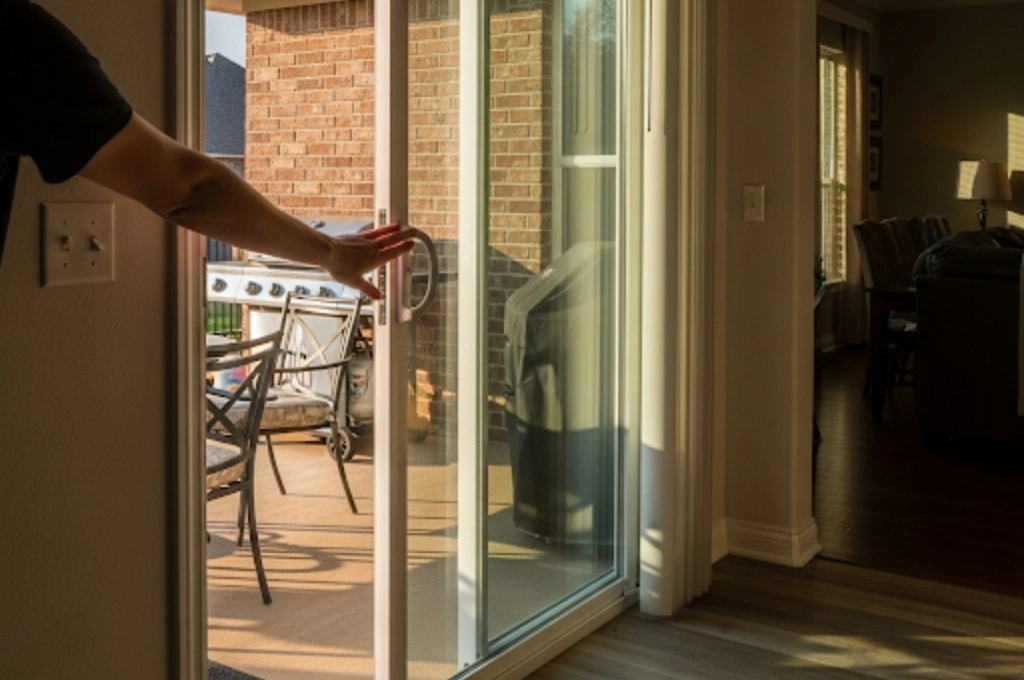 A family's sliding glass patio door in Plano, TX, now gliding open effortlessly with one hand.