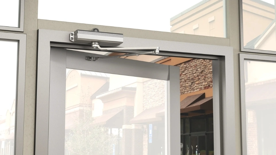 A commercial door closer repaired on a Plano business storefront, ensuring safe and smooth operation by Windows And Doors Repair LLC.