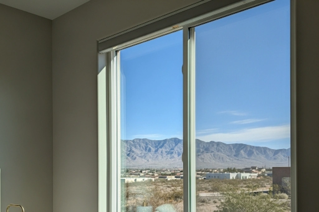 A crystal-clear, newly repaired double-pane window in an El Paso bedroom, showcasing a perfect view with no fog or condensation.