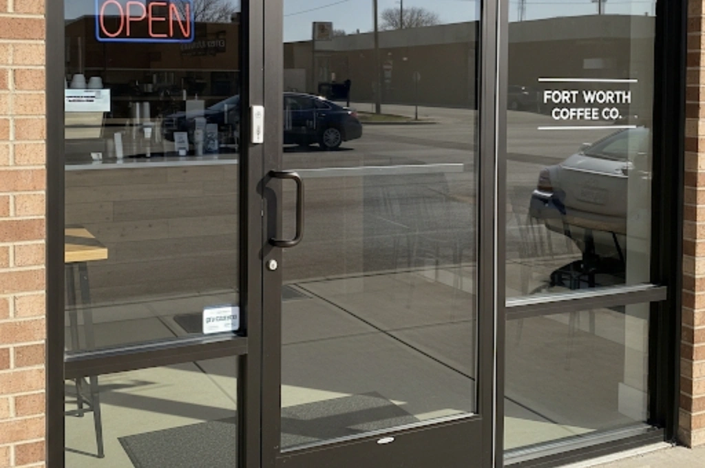 A secure, perfectly aligned commercial glass door on a Fort Worth coffee shop after our emergency door repair service.