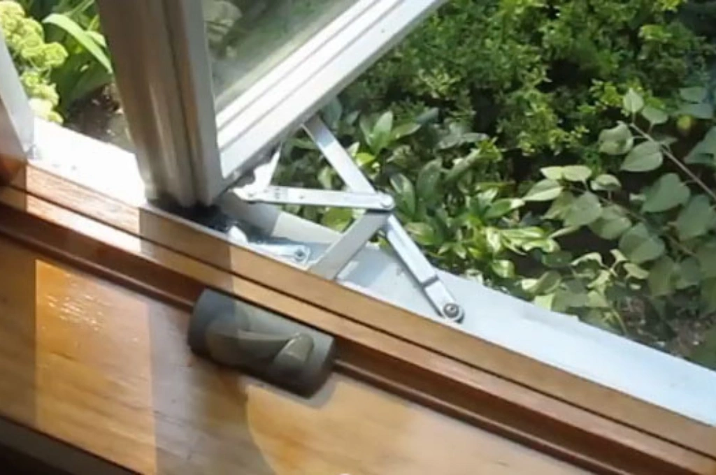 An expert technician from Windows And Doors Repair LLC performing a skilled mechanical window repair in Garland, saving the homeowner from a costly replacement.