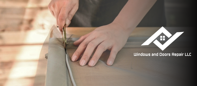 A technician from Windows And Doors Repair LLC expertly installing new screen mesh into a window frame.