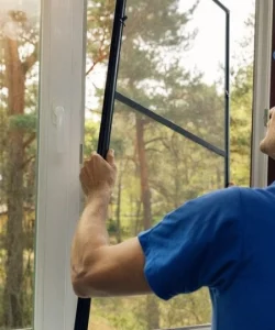 A certified technician from Windows And Doors Repair LLC demonstrating the quality materials used for window screen repair Garland.