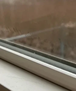 A foggy, moisture-filled double-pane window.