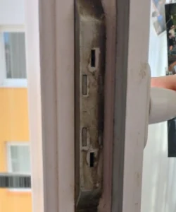 A professional technician performing an expert door repair on a modern brick home in a Dallas neighborhood.