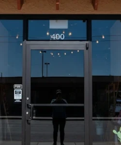 A skilled technician from Windows And Doors Repair LLC adjusting the alignment of a residential front door in El Paso, TX.